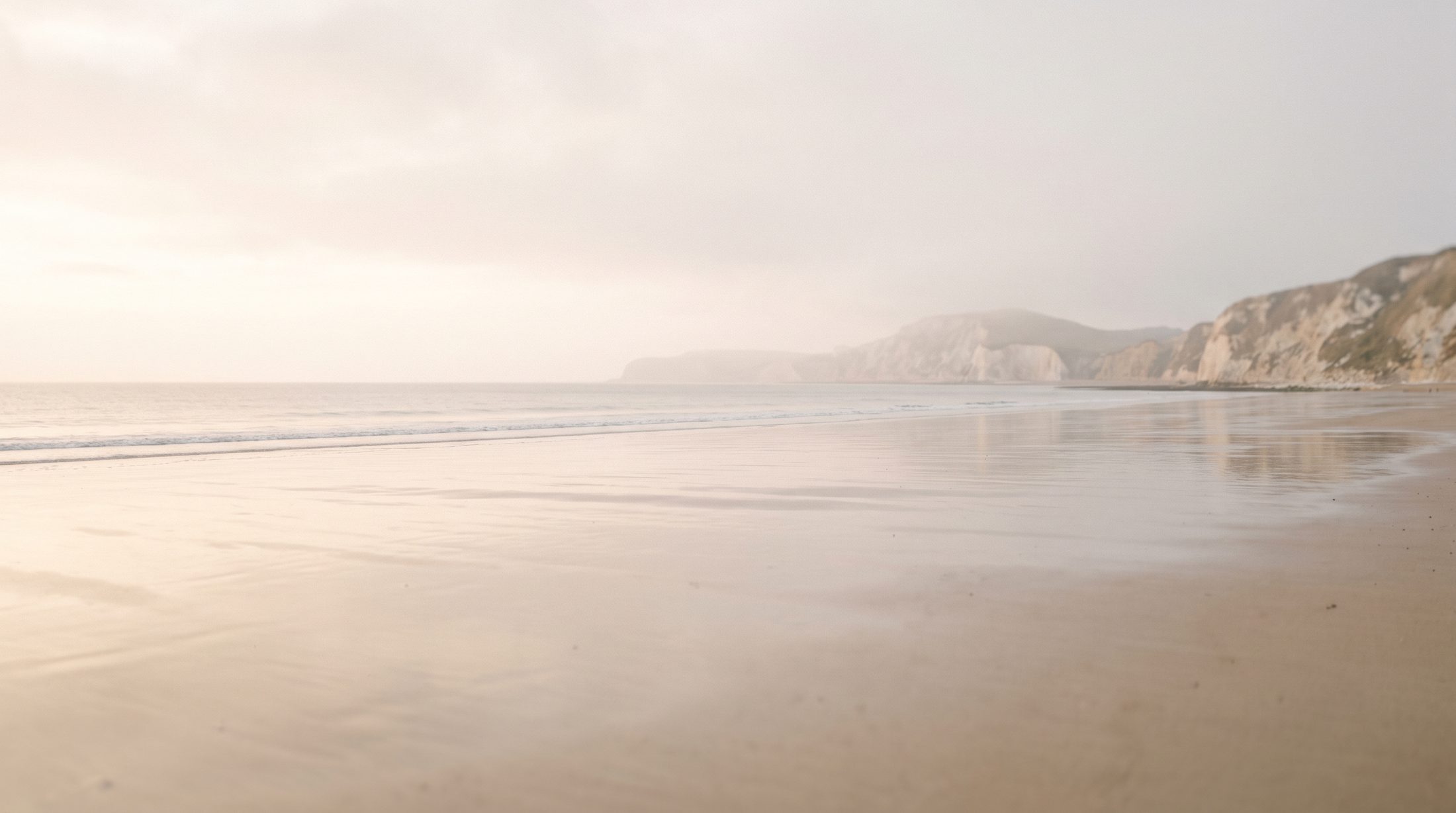 Calm, wide Dorset beach at soft dawn